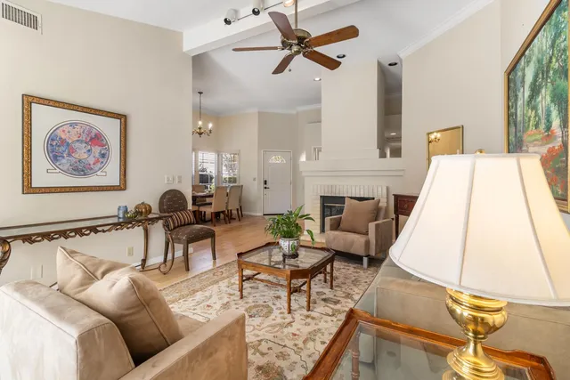 a living room with furniture and a dining table with wooden floor