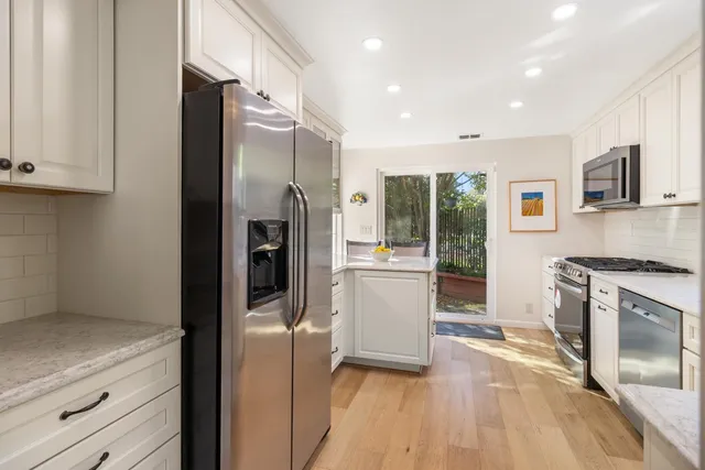 a view of a kitchen with a sink microwave and cabinets