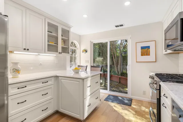 a kitchen with a refrigerator sink and cabinets