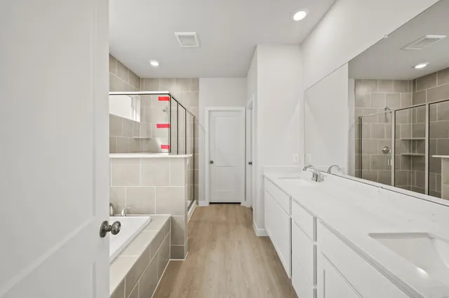 a spacious bathroom with a tub sink and mirror