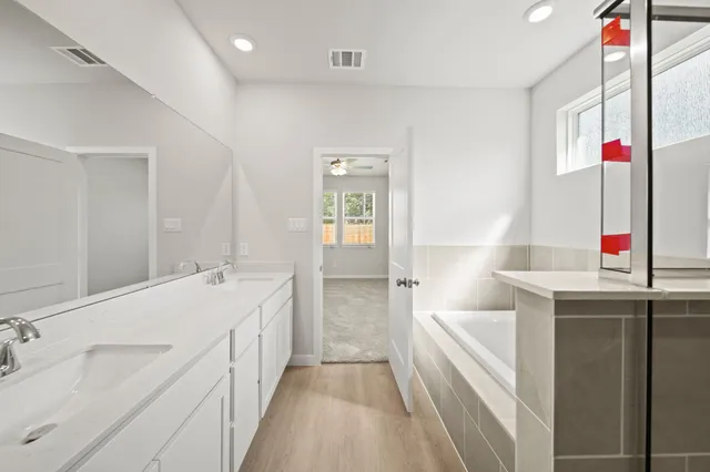 a bathroom with a tub sink and mirror
