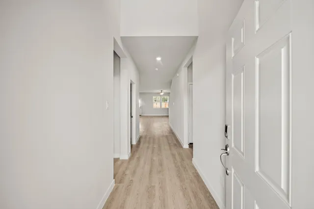 a view of a hallway with wooden floor and staircase