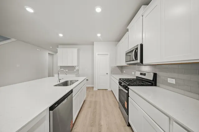 a kitchen with stainless steel appliances a sink stove and cabinets