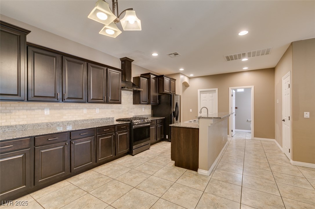 11063 Mt George Street Las Vegas, NV 89179 - Photo 17 of 49 Kitchen with gas range, dark brown cabinets, wall