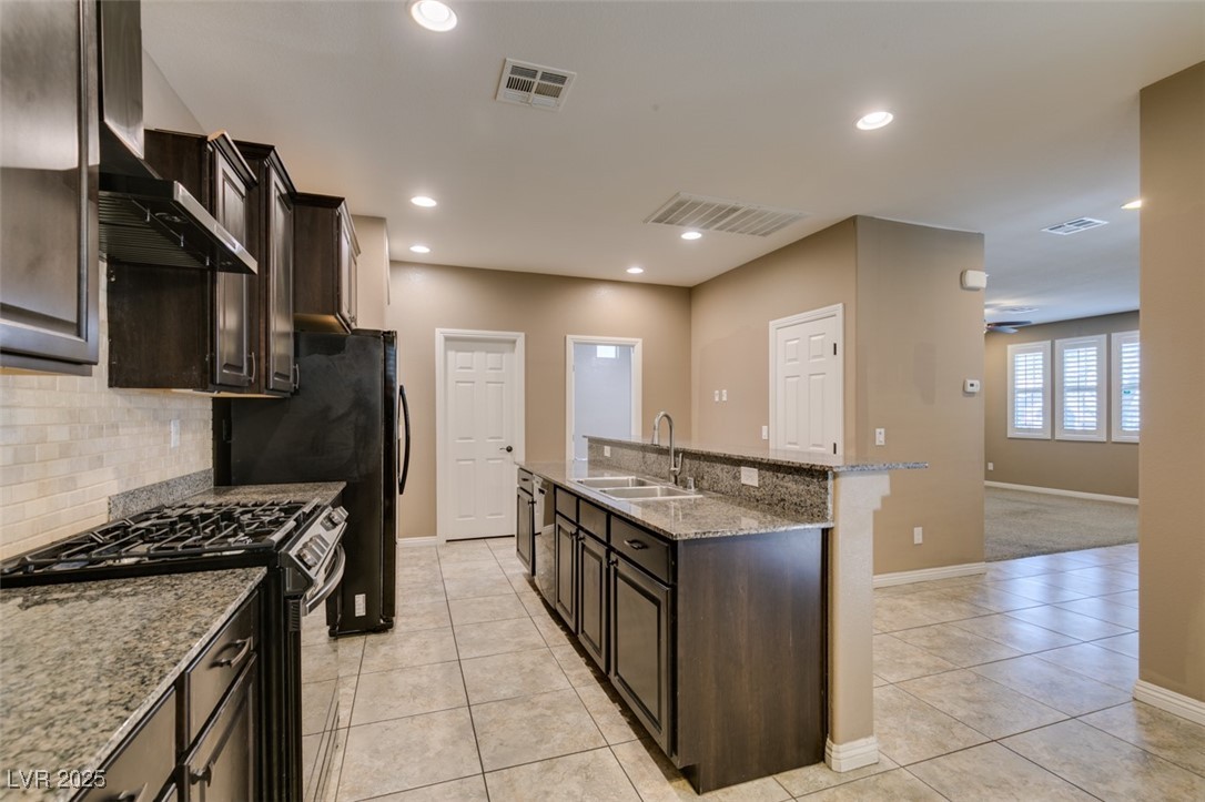 11063 Mt George Street Las Vegas, NV 89179 - Photo 20 of 49 Kitchen with gas range, an island with sink, light