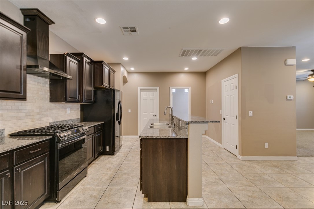 11063 Mt George Street Las Vegas, NV 89179 - Photo 21 of 49 Kitchen with black appliances, wall chimney exhaus