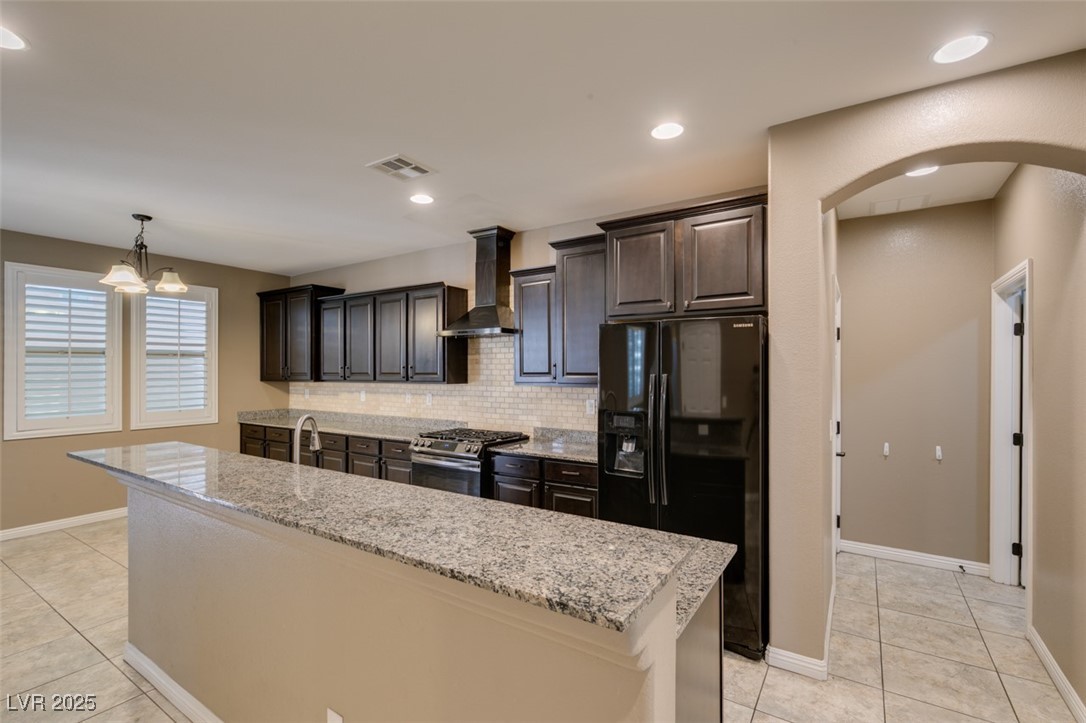 11063 Mt George Street Las Vegas, NV 89179 - Photo 24 of 49 Kitchen with arched walkways, black fridge with ic