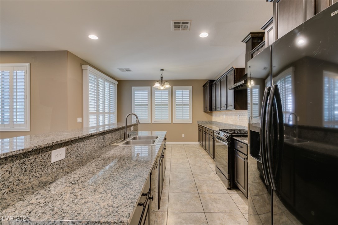 11063 Mt George Street Las Vegas, NV 89179 - Photo 25 of 49 Kitchen with black appliances, tasteful backsplash