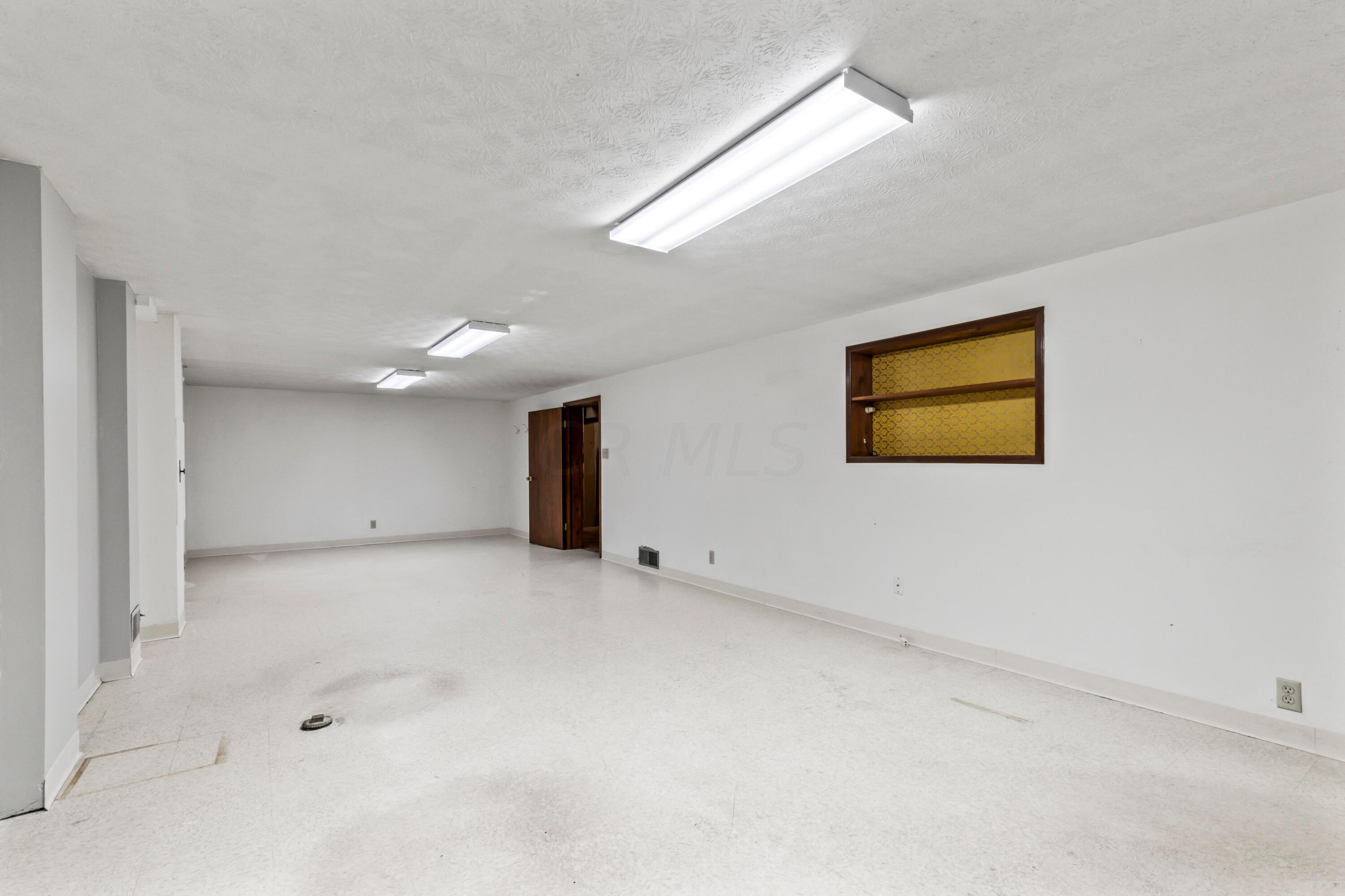 7020 Rieber Street Columbus, OH 43085 - Photo 37 of 40 • Linoleum tile flooring • Ivory painted walls • (3) New ceiling lights ~ 2017 • Two windows • Built-in bookcases