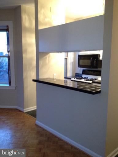 1851 Columbia Road Northwest, Unit 608 Washington, DC 20009 - Photo 2 of 16 a kitchen with kitchen island a sink appliances and a window