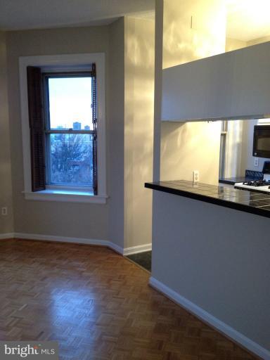 1851 Columbia Road Northwest, Unit 608 Washington, DC 20009 - Photo 12 of 16 an empty room with wooden floor and windows