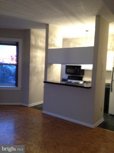 1851 Columbia Road Northwest, Unit 608 Washington, DC 20009 - Photo 14 of 16 a kitchen with granite countertop a refrigerator and a stove