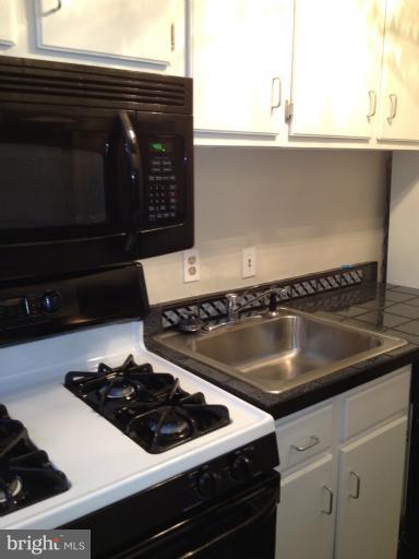 1851 Columbia Road Northwest, Unit 608 Washington, DC 20009 - Photo 15 of 16 a close view of a stove a microwave and a counter space