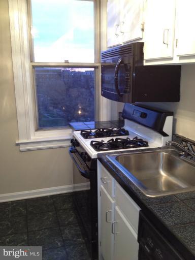 1851 Columbia Road Northwest, Unit 608 Washington, DC 20009 - Photo 9 of 16 a kitchen with granite countertop a sink and a stove