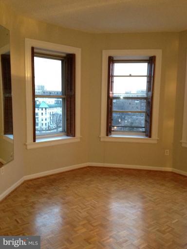 1851 Columbia Road Northwest, Unit 608 Washington, DC 20009 - Photo 10 of 16 a view of an empty room with wooden floor and a window