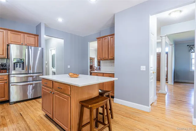 a kitchen with kitchen island a refrigerator stove and wooden floor
