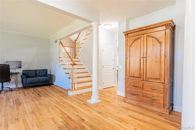 a view of a livingroom with wooden floor and stairs