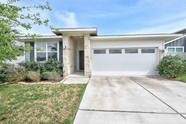 a view of a house with a yard and potted plants