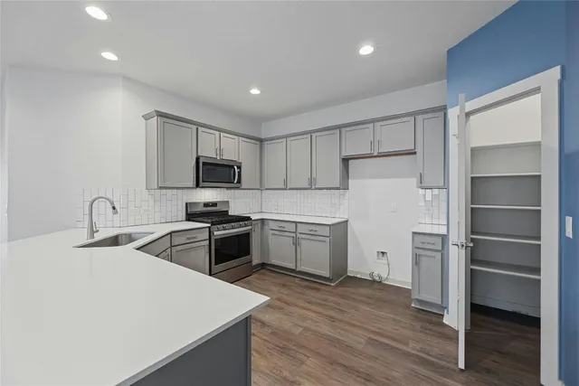 a kitchen with sink a microwave and cabinets