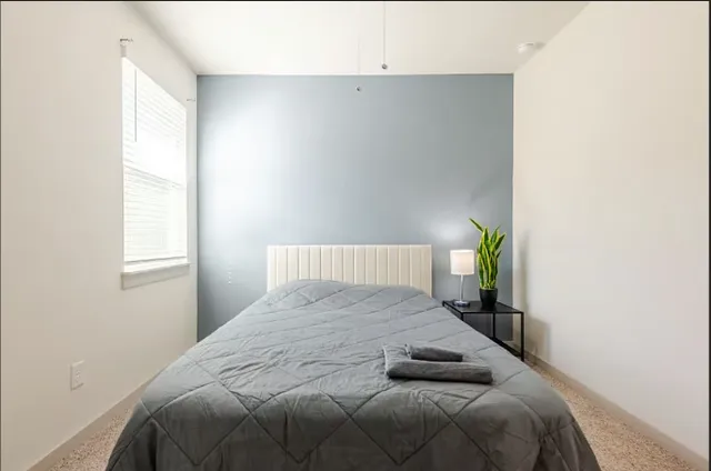 an empty room with a window and ceiling fan