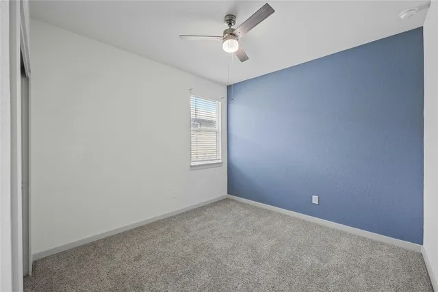 an empty room with closet and fan