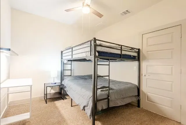an empty room with a window and ceiling fan