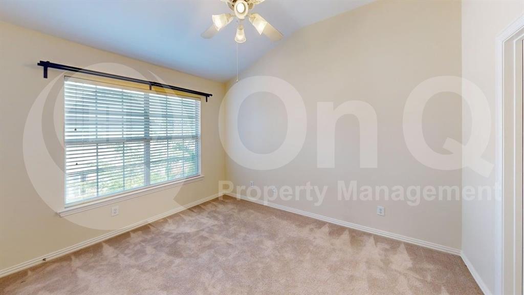 18240 Midway Road, Unit 1204 Dallas, TX 75287 - Photo 5 of 27 Carpeted room featuring a vaulted ceiling with a flush-mount ceiling fan, a large window with blinds, and light-toned walls