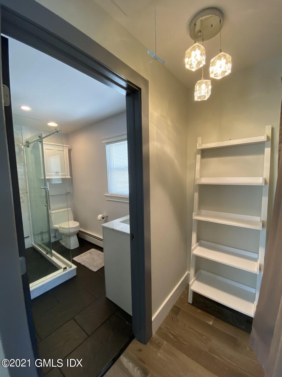 52 Prospect Street, Unit 2 Greenwich, CT 06830 - Photo 2 of 17 a room with a mirror and a fan