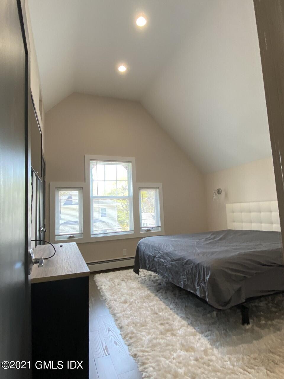 52 Prospect Street, Unit 2 Greenwich, CT 06830 - Photo 4 of 17 a spacious bedroom with a bed and a dresser with wooden floor