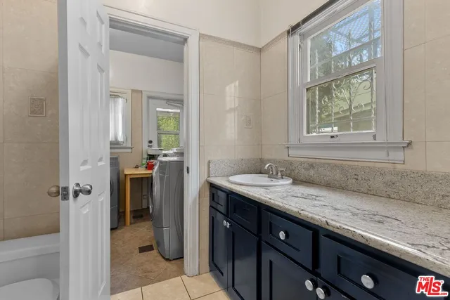 a bathroom with a granite countertop sink and a mirror
