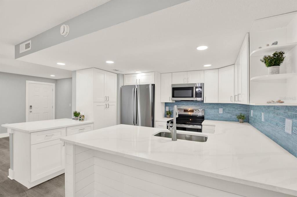 337 Rex Place, Unit A Madeira Beach, FL 33708 - Photo 11 of 48 a kitchen with sink cabinets and refrigerator