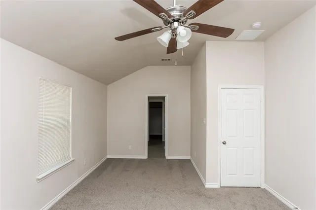 a view of an empty room with a ceiling fan