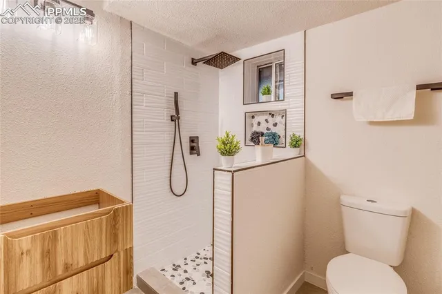 a backyard of a house with large trees and wooden fence