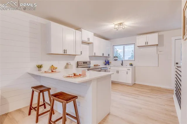 a kitchen with granite countertop white cabinets and white appliances