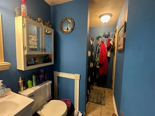 a bathroom with a toilet sink vanity and mirror
