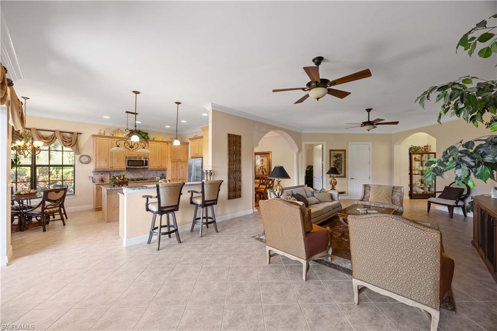 9105 Prima Way, Unit 102 Naples, FL 34113 - Photo 11 of 49 a living room with lots of furniture and a chandelier