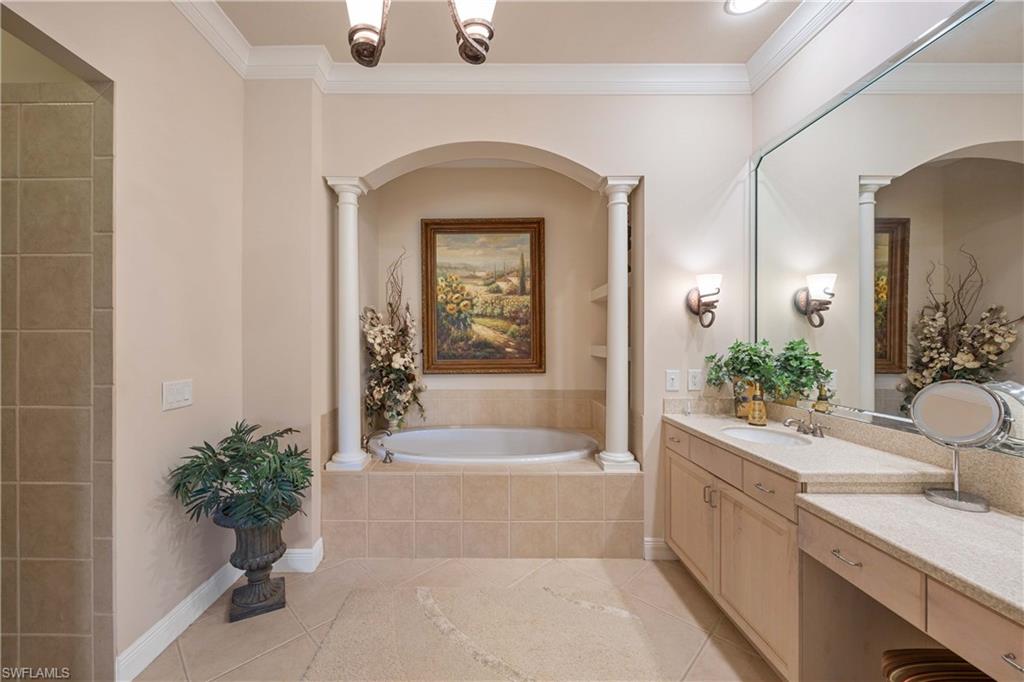 9105 Prima Way, Unit 102 Naples, FL 34113 - Photo 19 of 49 a bathroom with a tub sink and mirror