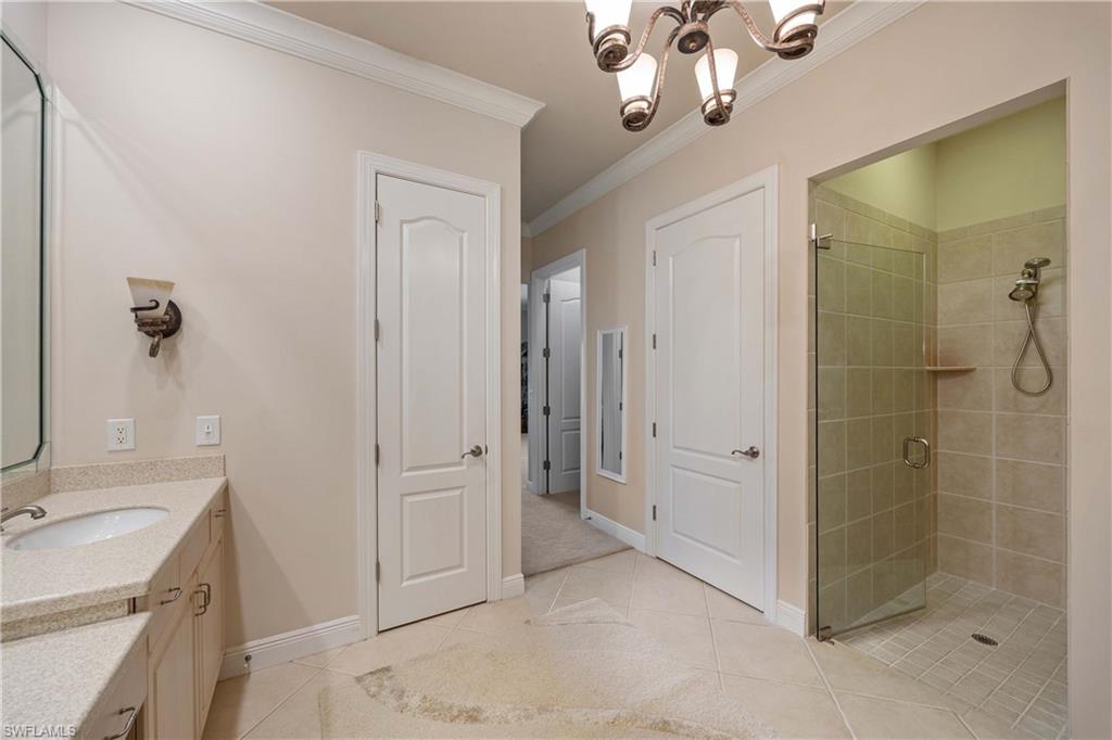 9105 Prima Way, Unit 102 Naples, FL 34113 - Photo 21 of 49 a bathroom with a shower sink and mirror