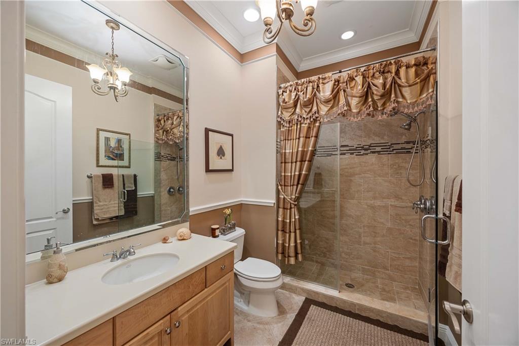 9105 Prima Way, Unit 102 Naples, FL 34113 - Photo 25 of 49 a bathroom with a granite countertop sink toilet a mirror a vanity and shower