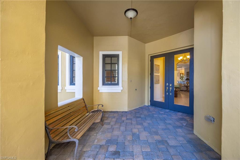 9105 Prima Way, Unit 102 Naples, FL 34113 - Photo 6 of 49 a view of a hallway with wooden floor and a bathroom