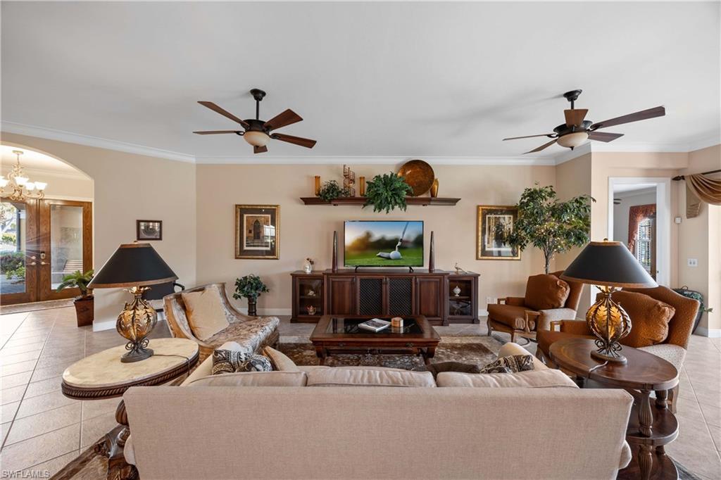 9105 Prima Way, Unit 102 Naples, FL 34113 - Photo 9 of 49 a living room with furniture a fireplace and a chandelier