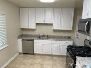 a kitchen with granite countertop white cabinets and white appliances