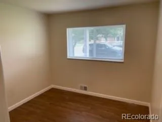 a view of a small space with wooden floor and a window