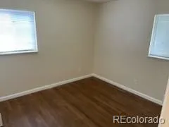 a view of a small space with wooden floor and a window