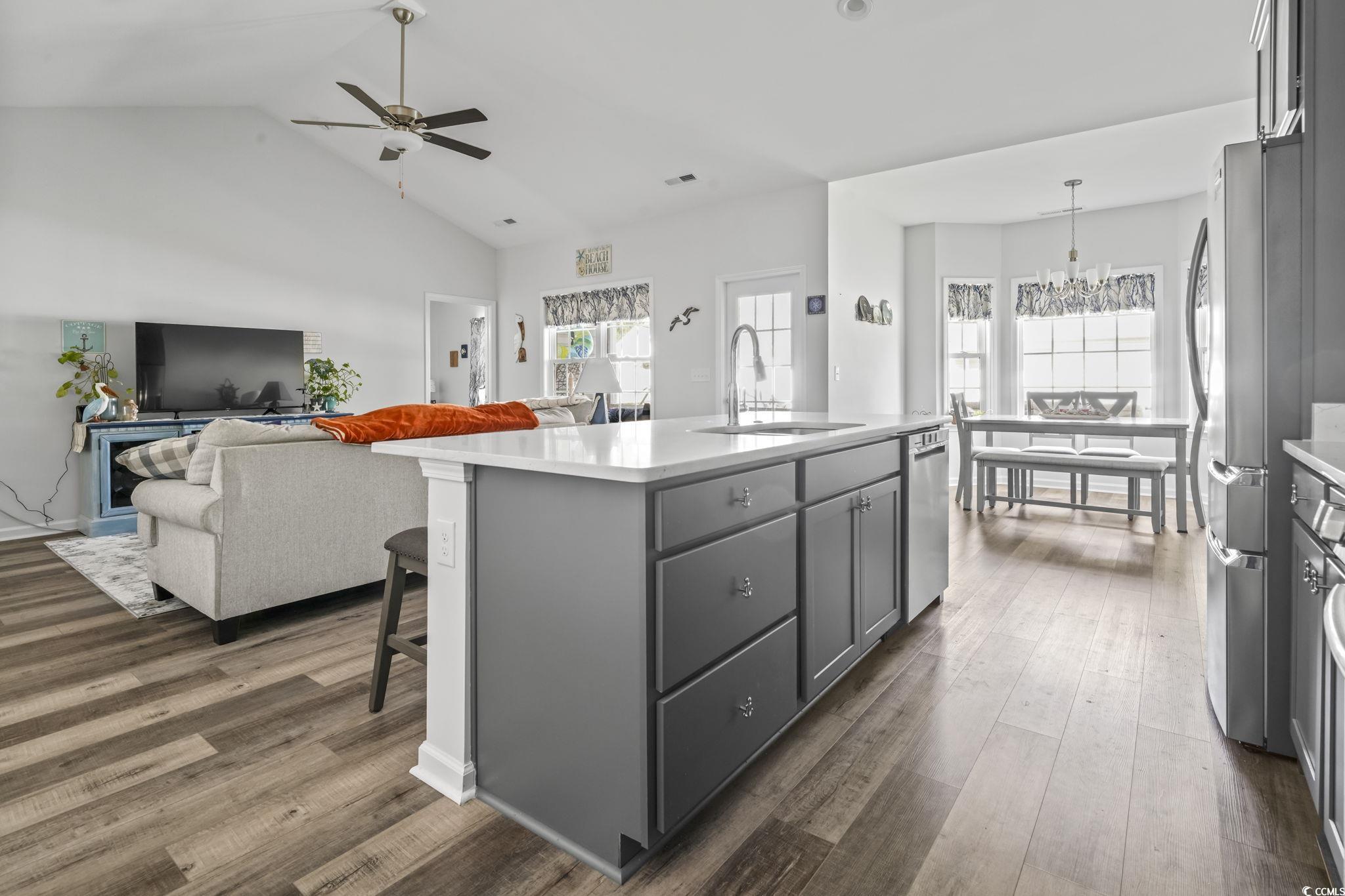308 Concorde Drive Georgetown, SC 29440 - Photo 40 of 40 Kitchen featuring luxury vinyl plank floors, a breakfast bar, open floor plan, a kitchen island with sink, and appliances with stainless steel finishes