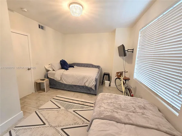 a bedroom with a bed and a large window