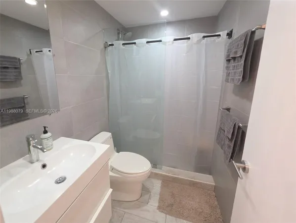 a white toilet sitting next to a bathroom sink