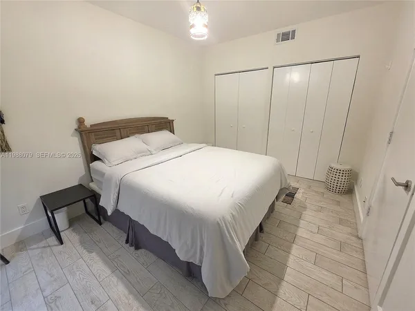 a large bed sitting in a bedroom next to a bathroom sink