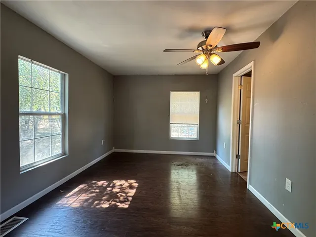 a view of a livingroom with a ceiling fan and window
