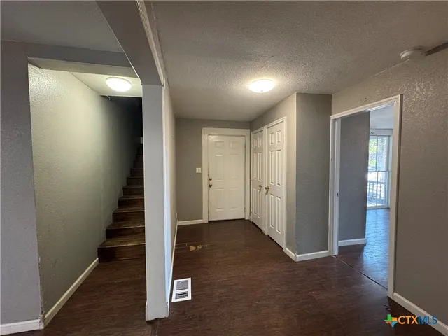 a view of a hallway with wooden floor